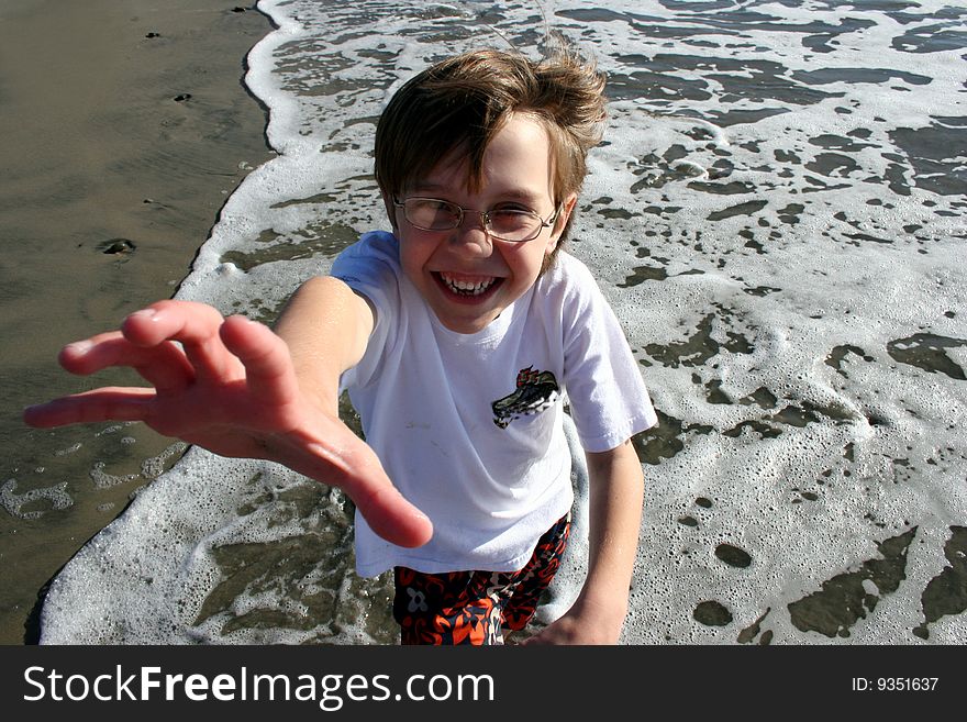 Boy at beach reaching up at you. Boy at beach reaching up at you