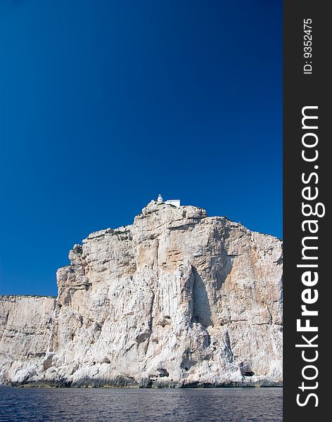 Italian lighthouse in Sardinia against blue sky