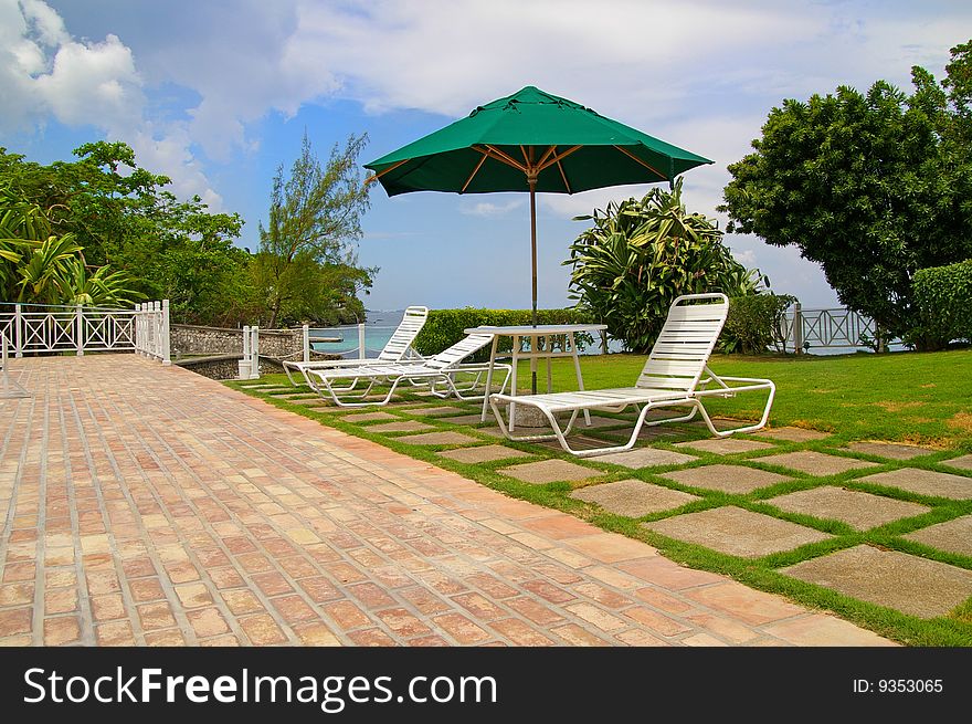 Lawn-chairs by poolside and blue sky