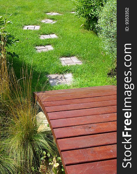 Garden stone path with grass growing up between the stones