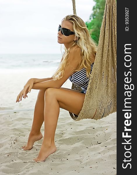 Girl sitting in hammock on the beach. Girl sitting in hammock on the beach