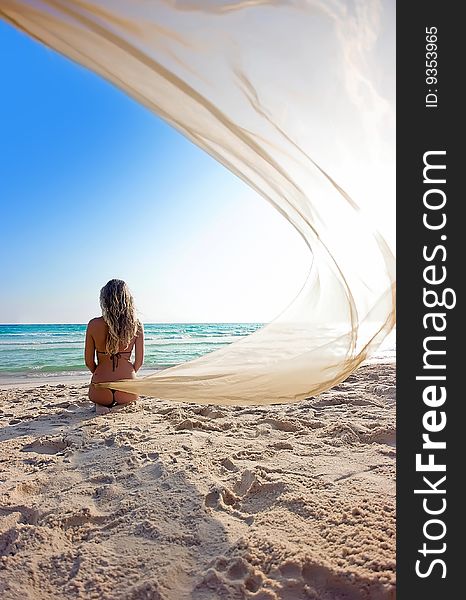 Blonde girl on the beach with shawl