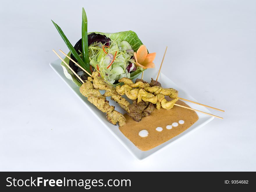 Beef and pork skewers with a salad isolated on a white background