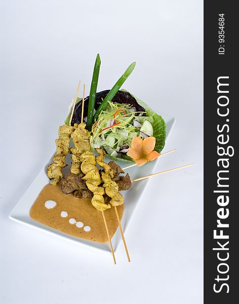 Beef and pork skewers with a salad isolated on a white background