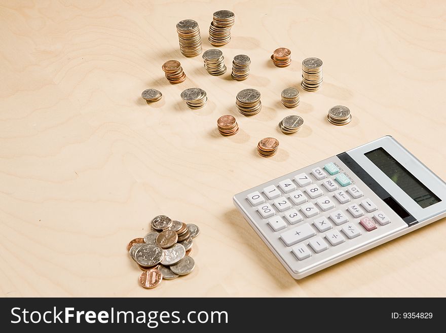 Stacks of change and calculator on desk. Stacks of change and calculator on desk