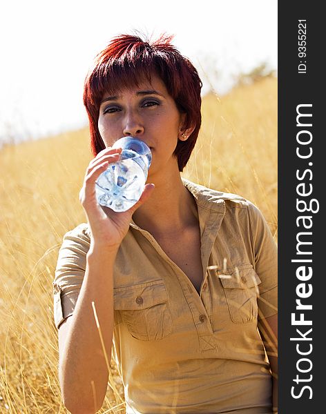 Woman drinks bottle of water outdoors. Woman drinks bottle of water outdoors