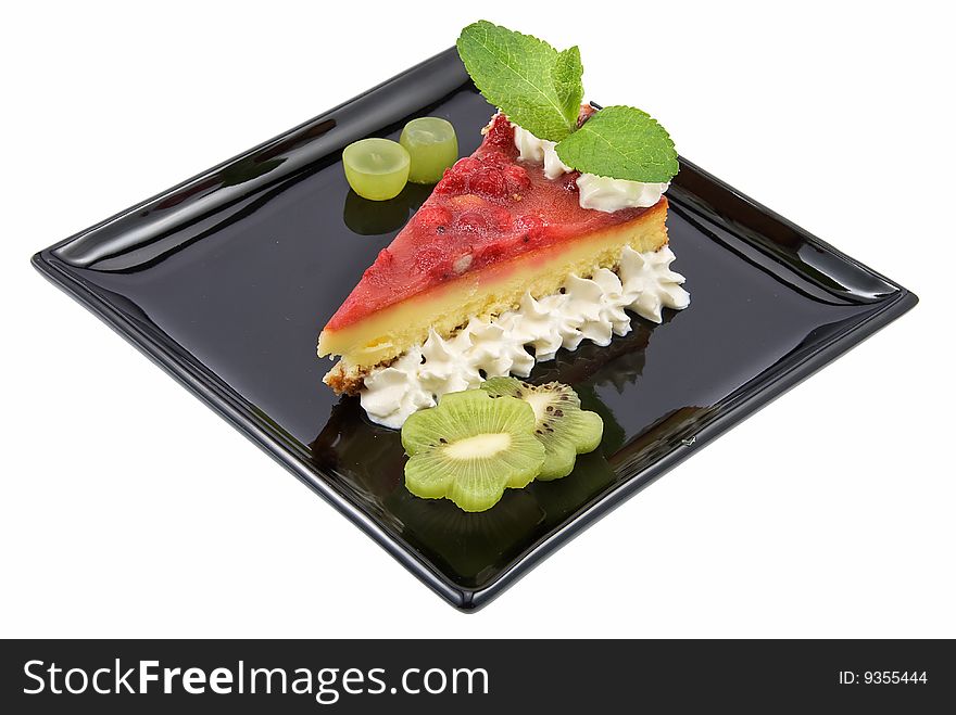 Cheesecake with berries on black plate isolated