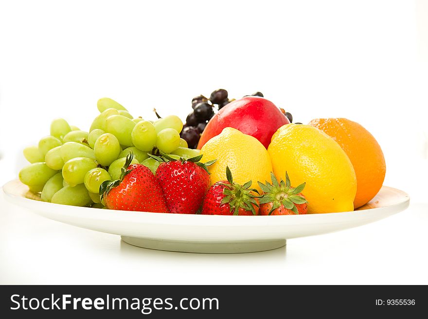 Fruit Platter with Red Grapes, Green Grapes, Mango, Lemon, Orange and Strawberry on white