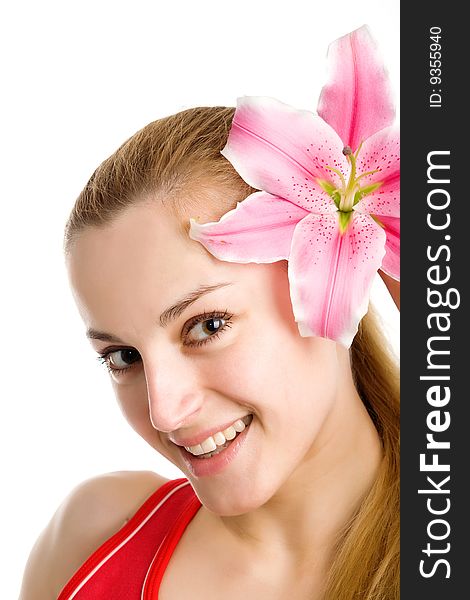 A smiling nice blond girl in red posing with a pink lily near her face on a white background. A smiling nice blond girl in red posing with a pink lily near her face on a white background