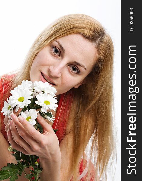 A smiling beautiful blonde in red with a bouquet of white chrysanthemums in her hands. A smiling beautiful blonde in red with a bouquet of white chrysanthemums in her hands