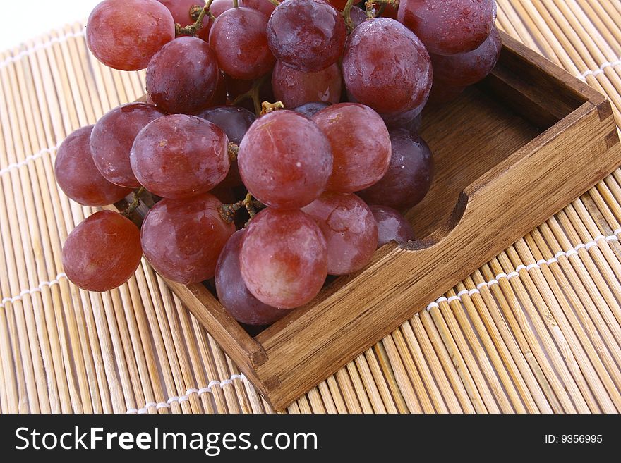 The bunch of ripe red grapes on the white background