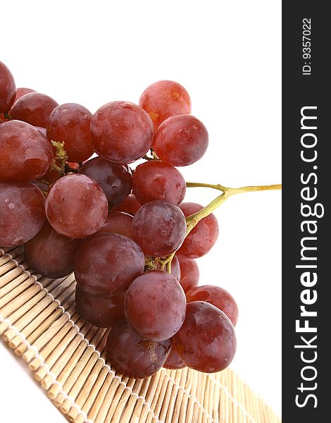 The bunch of ripe red grapes on the white background