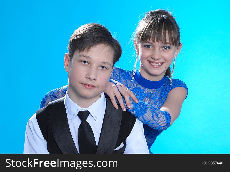 Boy and girl posing in studio on blue background