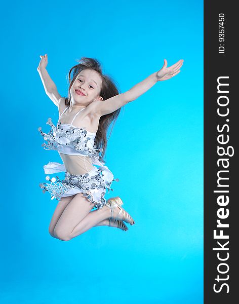 Little handsome jumping girl on blue background