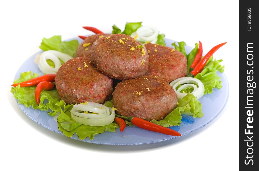 Meat rissoles with cayenne on a round plate