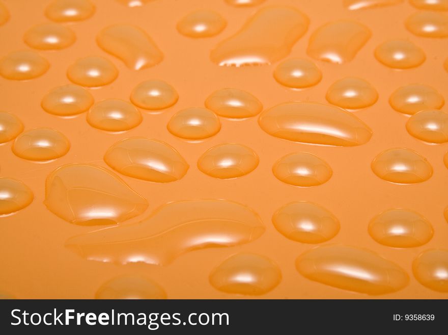 Orange drops of water on a smooth surface