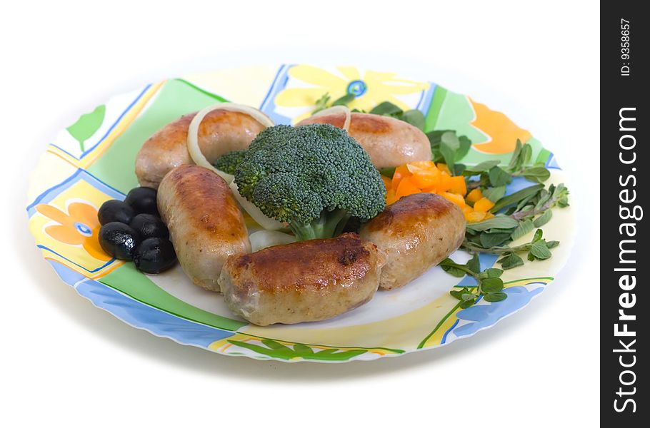 Small sausages with cauliflower and olives on a round plate