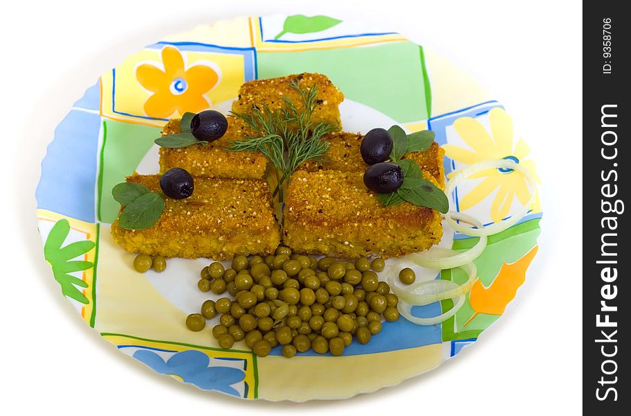 Meat cutlets with green peas and olives on a round plate