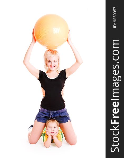 Young mother with a big ball and a small son do morning exercises. Young mother with a big ball and a small son do morning exercises