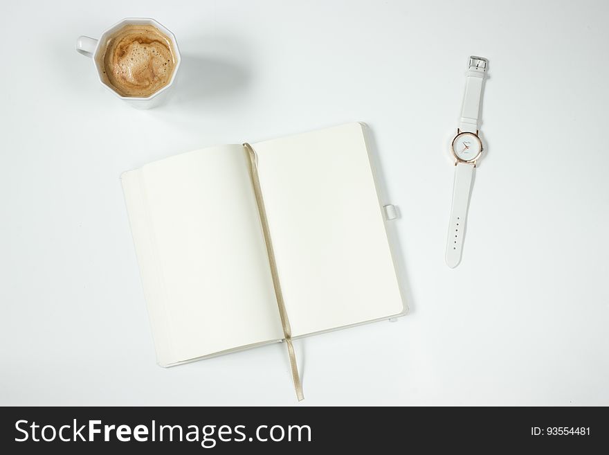 White Leather Strap Silver Round Analog Watch Next To Notebook