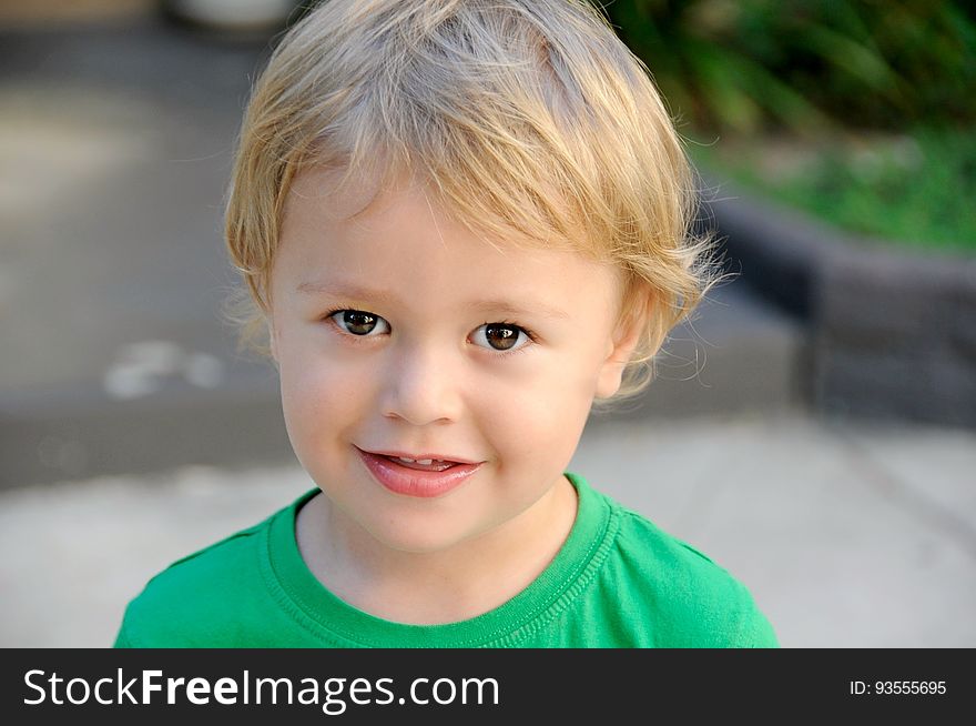 Closeup outdoor portrait of a blond toddler boy taken with shallow depth of field.