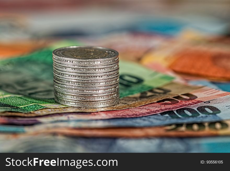 A stack of coins on paper money.