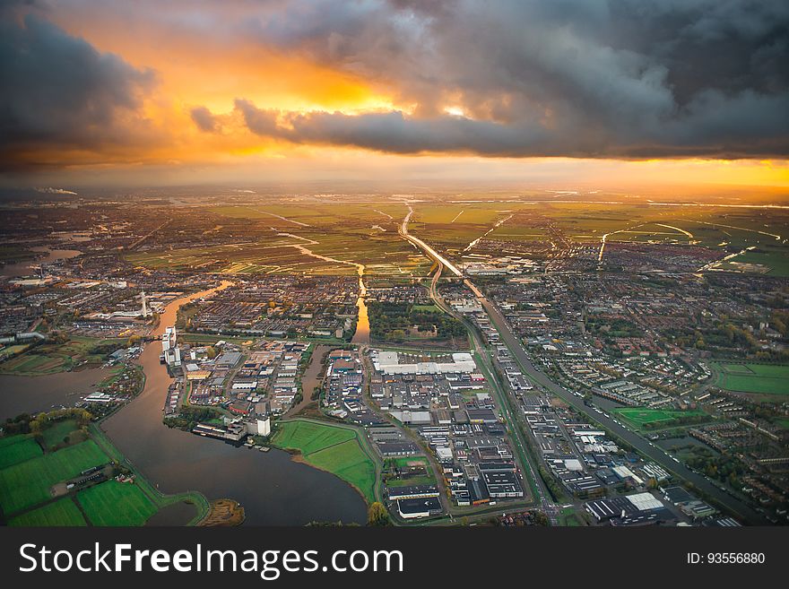 A city on the river delta with green fields at sunset. A city on the river delta with green fields at sunset.