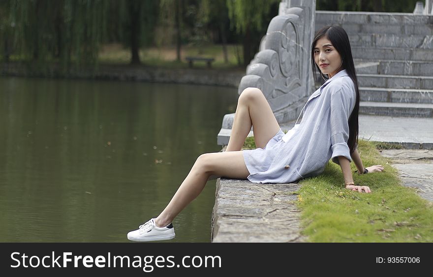 Woman Sitting beside a Lake