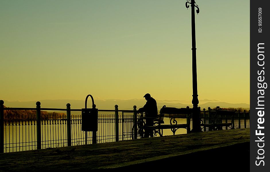 Silhouette Man On Street In City At Sunset