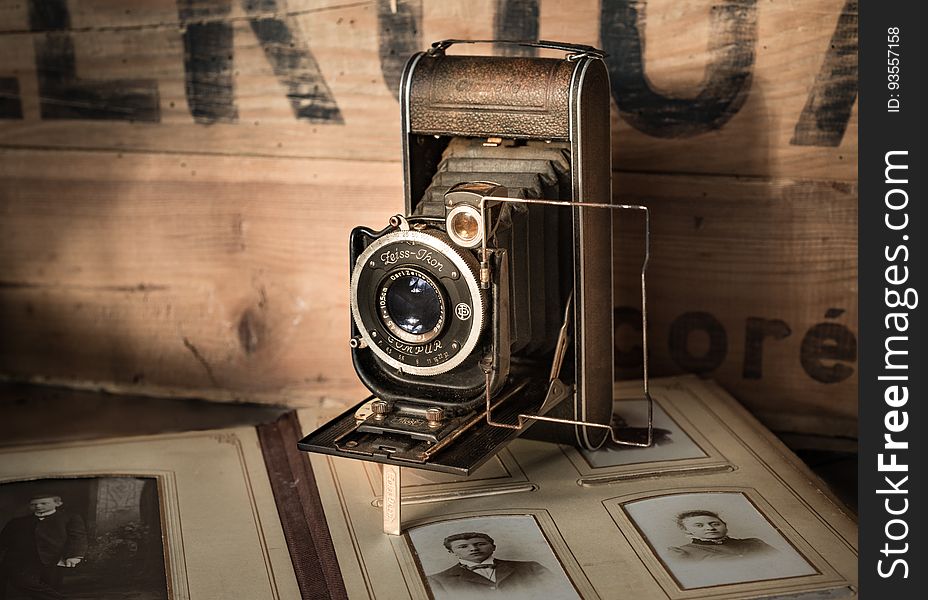 A retro film camera on top of an old album.