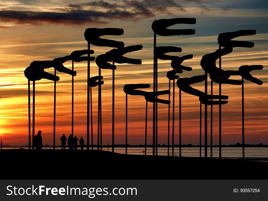 Silhouette Parasols Against Dramatic Sky during Sunset