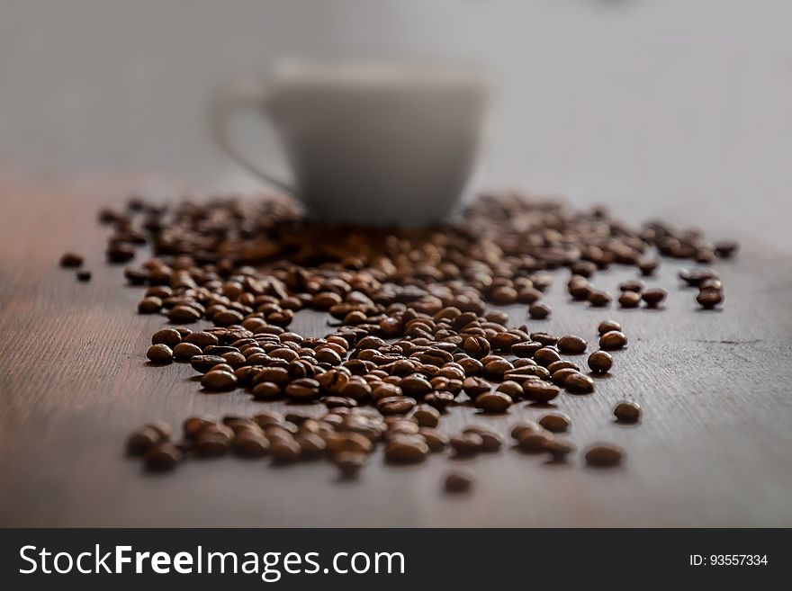 Background of coffee beans in front of a coffee cup. Background of coffee beans in front of a coffee cup.