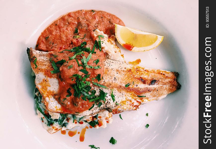 Closeup of a gourmet meal of fish with tomato puree.