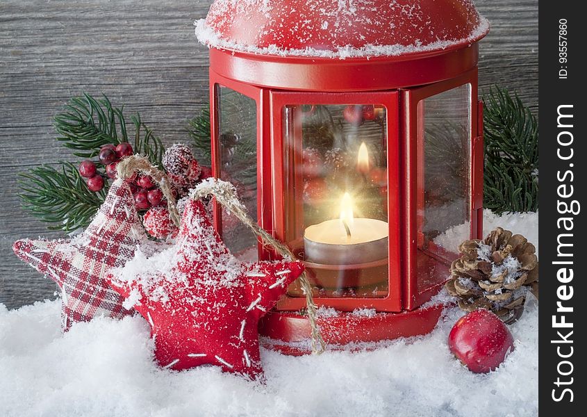 Christmas decorations around a red lantern with a tea light candle. Christmas decorations around a red lantern with a tea light candle.