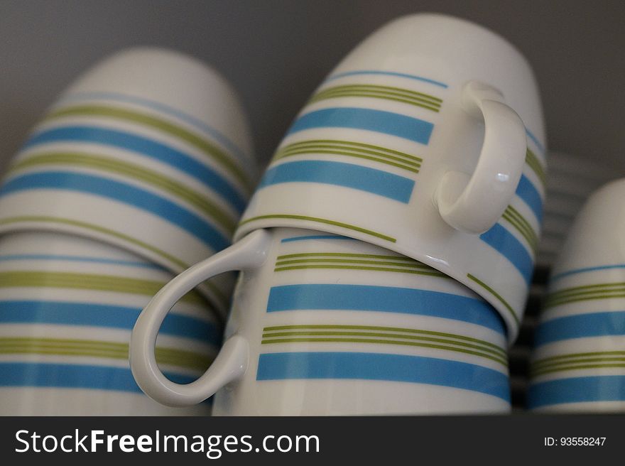 Striped mugs stacked on a shelf.