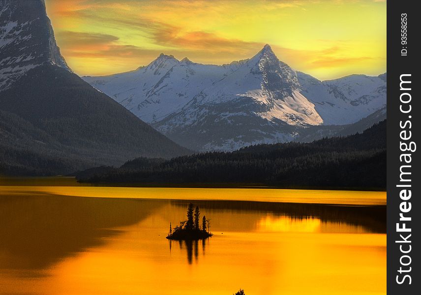 A beautiful Alaskan sunset framed by surrounding mountains is reflected onto a lake. A beautiful Alaskan sunset framed by surrounding mountains is reflected onto a lake.