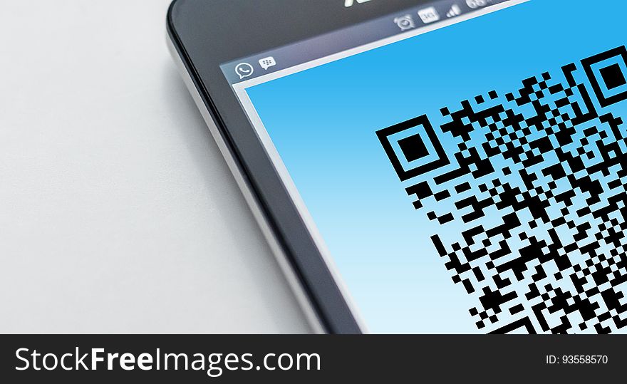 A smartphone with a QR code on the display. A smartphone with a QR code on the display.