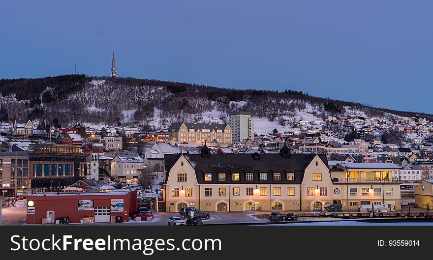 Houses in Norwegian town at dusk with snowy mountains in background. Houses in Norwegian town at dusk with snowy mountains in background.