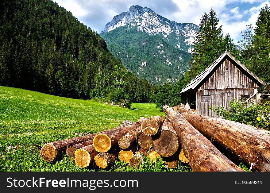 Lumber on a field near a mountain cabin. Lumber on a field near a mountain cabin.