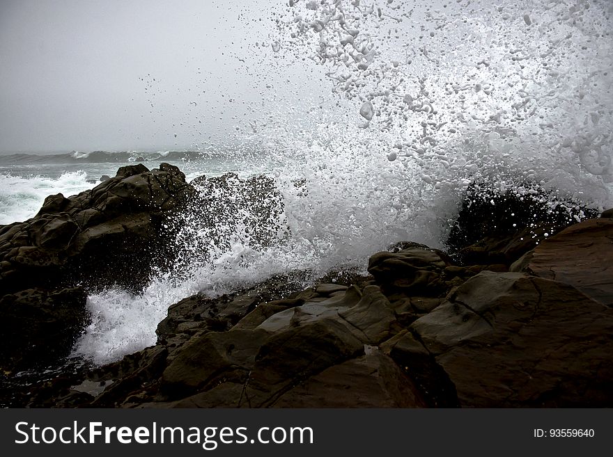 A view of a stormy sea with waves crashing on the rocks. A view of a stormy sea with waves crashing on the rocks.