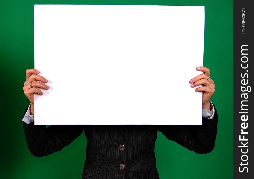 Person in a Black Coat Holding White Rectangular Board