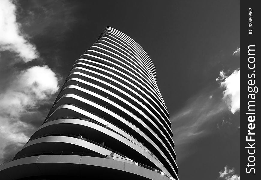 A black and white photo of a skyscraper with an organic shape. A black and white photo of a skyscraper with an organic shape.