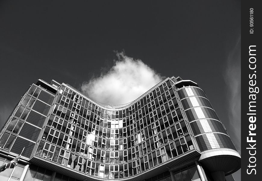 A black and white photo of a modern office building from a low angle.