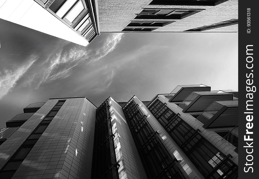 A low-angle view of a city in monochrome. A low-angle view of a city in monochrome.