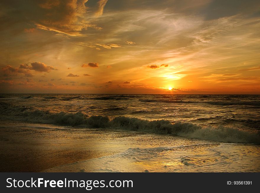 A sunset on a beach with colorful skies. A sunset on a beach with colorful skies.