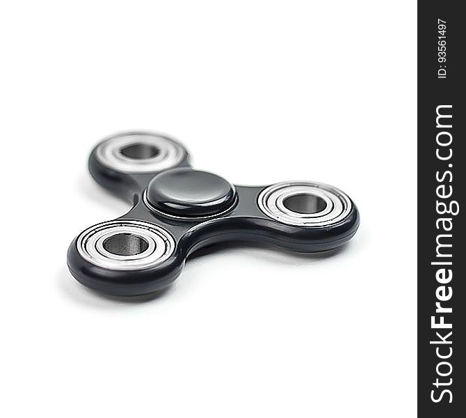 A close up of a metal fidget spinner on a white background.
