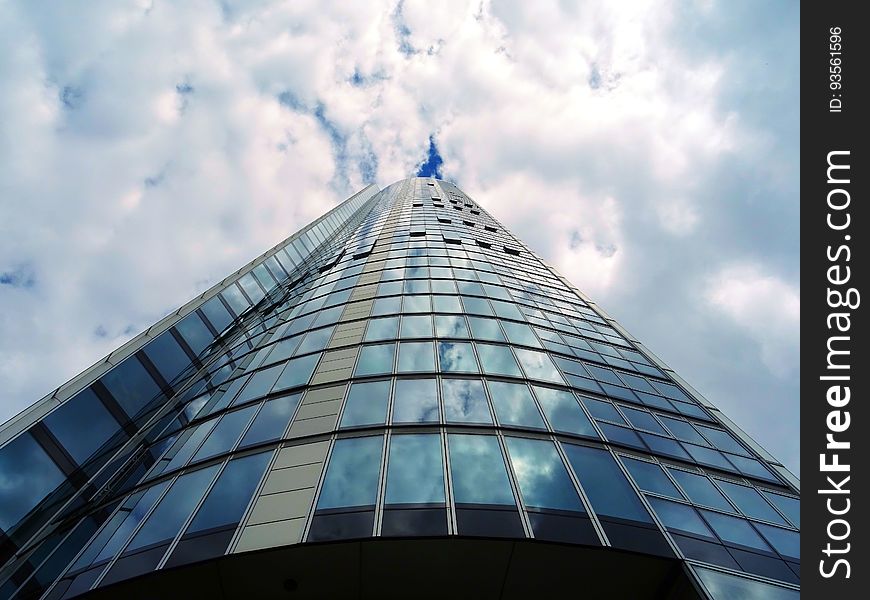 A tall modern glass building from a low angle.