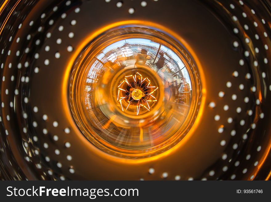 Close up of glass bulb in orange light fixture. Close up of glass bulb in orange light fixture.
