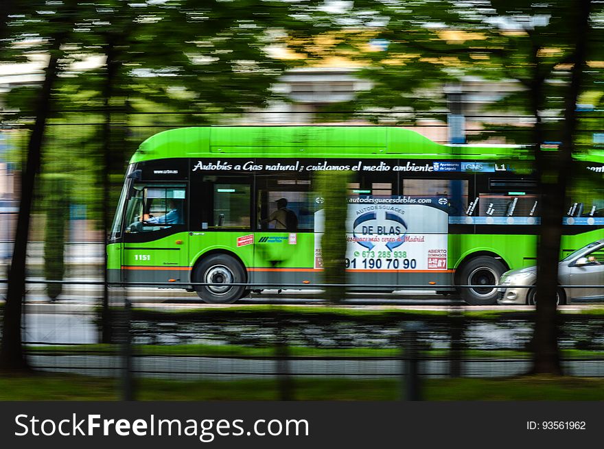 A green city bus on the street. A green city bus on the street.