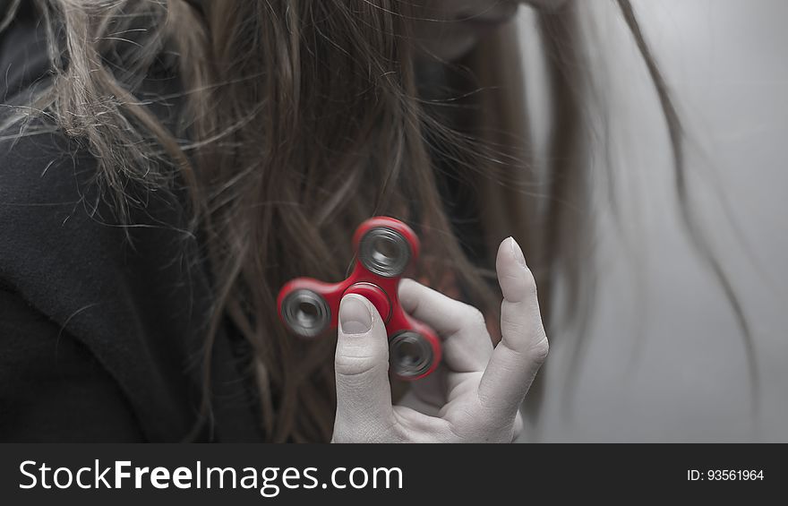 A girl holding up a fidget spinner. A girl holding up a fidget spinner.